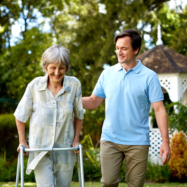 man helping elderly woman with a walker