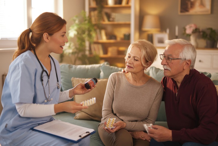 A nurse explaining medications to an elderly couple at home in Houston, TX